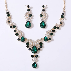 Detail view of gold bridal jewelry set with dark green teardrop crystals and rhinestones