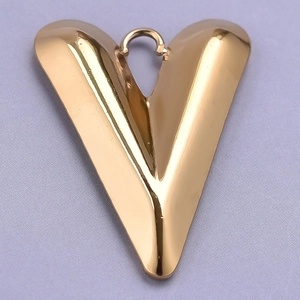 Macro shot of gold V-shaped heart pendant in polished 304 stainless steel on fabric