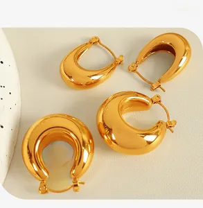 Detail of 18K gold-plated U-shaped and wide C-shaped thick hoop earrings with polished finish