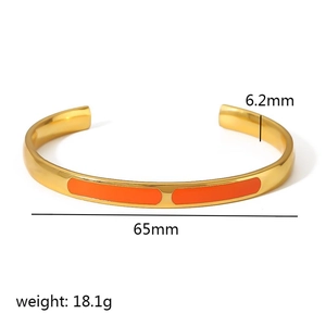 Detail showing 6.2mm width and 65mm diameter of gold and orange enamel open bangle