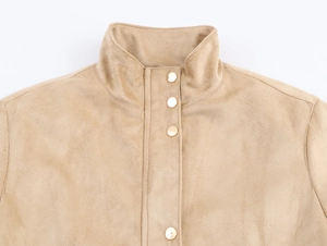 Détail de la veste en daim camel avec col montant et quatre boutons-pression en métal doré
