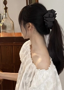 Elegant profile view of a model wearing the black ribbon banana clip in a warm setting