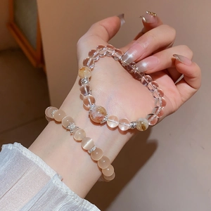 Gros plan d'un bracelet double en perles de cristal avec pendentifs étoiles en argent