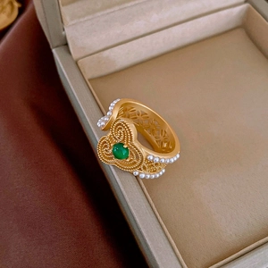 Detail of vintage gold butterfly ring with green agate stone and small pearls