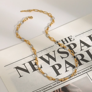 Elegant two-tone gold and silver link chain necklace on a newspaper background