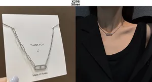 Detail view of silver hip-hop necklace with asymmetric paperclip chains and H-pendant
