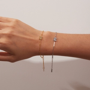 Detail of titanium steel letter bracelets with pavé zircons in gold and silver finish