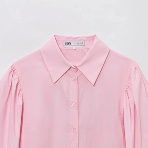 Women's stylish pink poplin long sleeve shirt with lapel collar shown in flat lay view