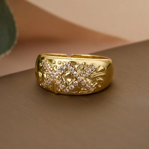 Irregular geometric gold ring with floral embossed patterns and sparkling crystals