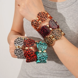 Close-up of leopard print acrylic bracelets with gold metal connectors in various colors
