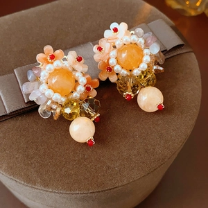 Gros plan détaillé de boucles d'oreilles fleur faites main avec perles et cristaux