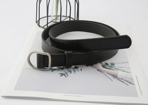 Detail of black faux leather belt with matte silver D-ring buckle and fine stitching