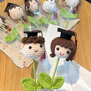 Detail of hand-crocheted graduation bouquets with dolls wearing black caps and red tassels