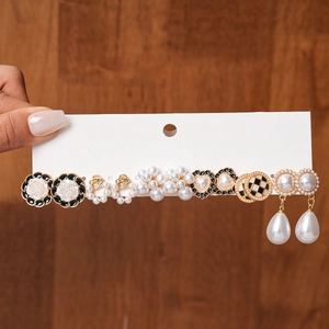 Detail of elegant earring set featuring faux pearls, rose shapes, and heart studs