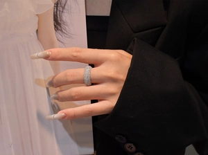 Close-up of five-row micro-pave diamond curved band ring in silver finish on hand