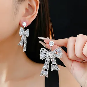 Luxury oversized bow-shaped earrings with inlaid diamonds and shiny silver finish