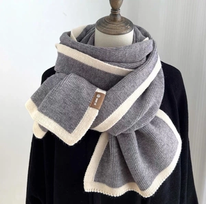 Minimalist grey and cream striped knit scarf with leather brand tag for winter warmth
