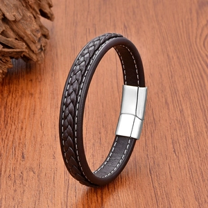 Detail of dark brown braided leather bracelet with white stitching and silver magnetic clasp