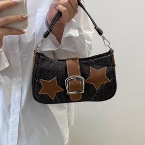 Detail of vintage denim shoulder bag with brown leather star applique and silver buckle