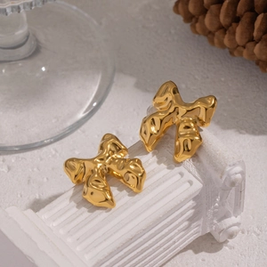 Elegant gold liquid metal bow earrings displayed on a white classical Roman column base