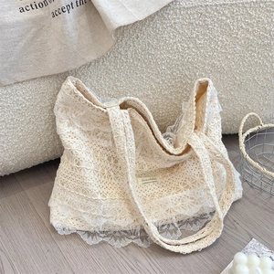 Close-up of the beige hollow crochet lace tote bag with delicate floral embroidery details