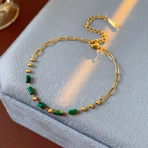 Détail du bracelet chaîne dorée vintage avec cylindres en pierre de malachite verte