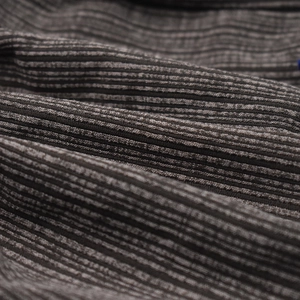 Detailed view of the dark grey ribbed knit fabric texture and vertical pattern for beanies