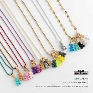 Detailed view of colorful resin gummy bear pendants with zircon-encrusted clasps