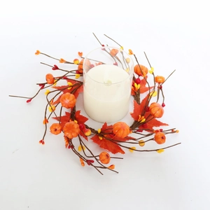 Detail of autumn candle ring with faux pumpkins, maple leaves, and a glass candle holder