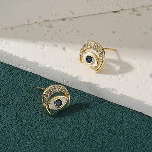 Elegant gold evil eye stud earrings with blue gemstone and shimmering micro-set crystals