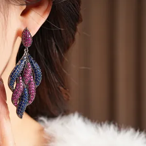Vintage silver needle earrings with pink and blue zircons shown on a model