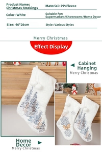 Detail of white velvet Christmas stocking with tree embroidery and plush pom-pom drawstrings