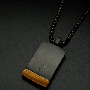 Close-up of black square pendant with tiger eye stone and engraved cross arrows
