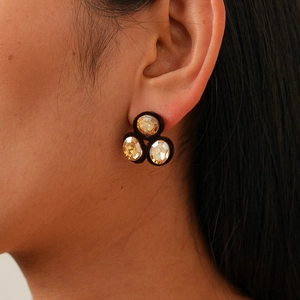 Close-up of vintage champagne crystal stud earrings with black velvet on model