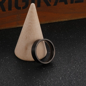 Minimalist matte black 6mm titanium steel ring shown on a wooden jewelry display cone