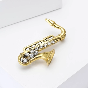 Macro shot of gold saxophone brooch detailing sparkling rhinestones and metal finish