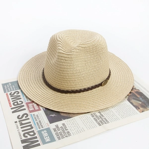 Close-up of straw sun hat with brown woven leather band and vintage metal buckle detail