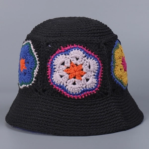 Detailed view of colorful floral crochet patterns on a black knit bucket hat