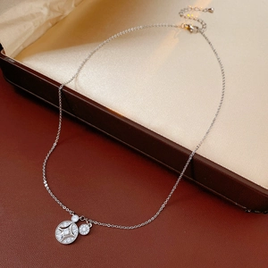 Détail du collier à double pendentif en argent avec zircone dans un écrin de luxe