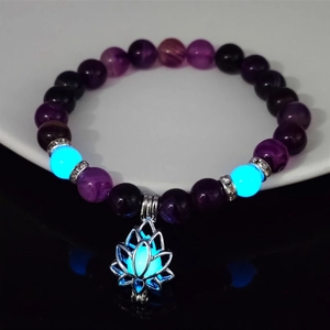 Detailed view of purple beads yoga bracelet with glowing blue beads and lotus charm