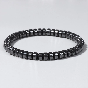 Macro shot of magnetic black hematite hexagonal beads on elastic bracelet for men