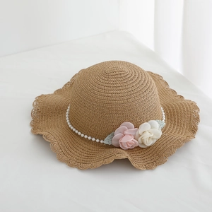 Detailed texture of straw hat brim with rose floral decor and white pearl chain