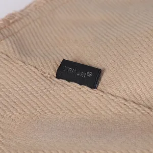 Macro shot of khaki corduroy bucket hat side featuring the YOU SHI woven brand label
