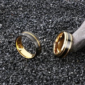 Macro detail of wide two-tone tungsten ring with magnetic stone insets on black gravel