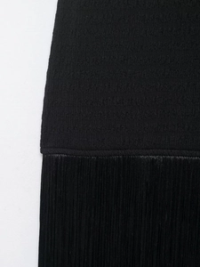 Vue détaillée de la robe noire avec texture plissée et accents de franges élégantes