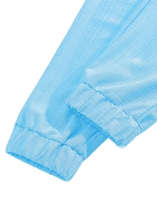 Close-up of light blue drawstring linen pants showing seersucker fabric texture and quality
