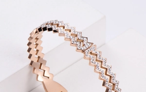 Close-up of rose gold geometric zigzag bracelet set with sparkling white crystals