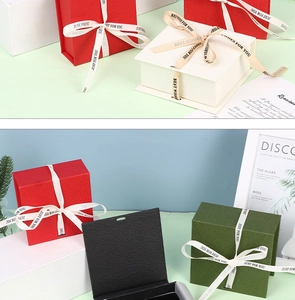 Close-up of open black textured paper jewelry gift box with personalized ribbon bow