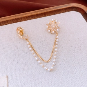 Detail of 14K gold plated Saturn chain brooch with star and moon motifs and pearls