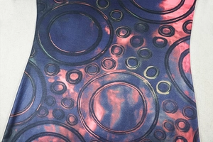 Close-up of geometric circle print on navy blue elastic knit fabric for women's dress